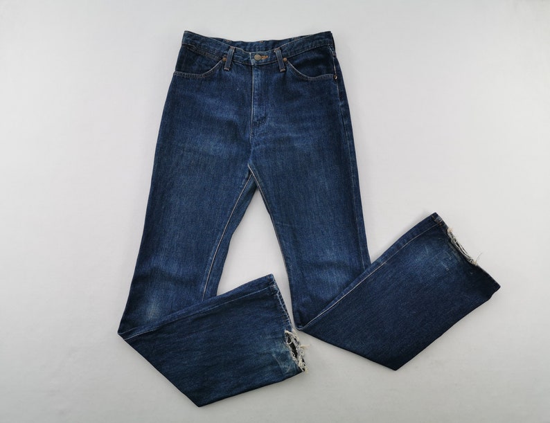 Peut inclure: Jean bleu fonc&eacute; &agrave; taille haute et jambe &eacute;vas&eacute;e. Le jean a une conception classique &agrave; cinq poches et une fermeture boutonn&eacute;e et zipp&eacute;e. L'ourlet du jean est effiloch&eacute;.
