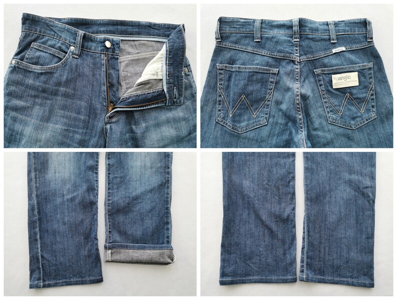 May include: Blue denim jeans with a button and zip fastening, front and back pockets, and the Wrangler logo. The jeans have a classic five-pocket design and a straight leg fit. The denim has a faded wash.