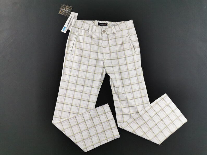 Op de afbeelding: Witte geblokte broek met een bruin en wit ruitpatroon. De broek heeft aan elke kant een ritszak.