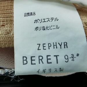 Puede incluir: Primer plano de una etiqueta de boina. La etiqueta dice "ZEPHYR BERET 9 3/4" e incluye texto en japon&eacute;s. La boina es de color beige claro. La etiqueta tambi&eacute;n incluye el texto "Made in England."
