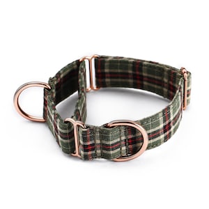 May include: A green, red, and black plaid dog collar with rose gold hardware. The collar features a D-ring and a sliding adjustment buckle. The fabric has a classic plaid pattern, suitable for a pet.