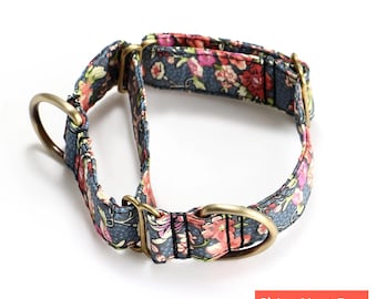 May include: A martingale dog collar featuring a dark blue fabric base with a white polka dot pattern and a colorful floral print of pink, red, and green flowers. The collar includes antique brass metal hardware, including two D-rings and sliders.