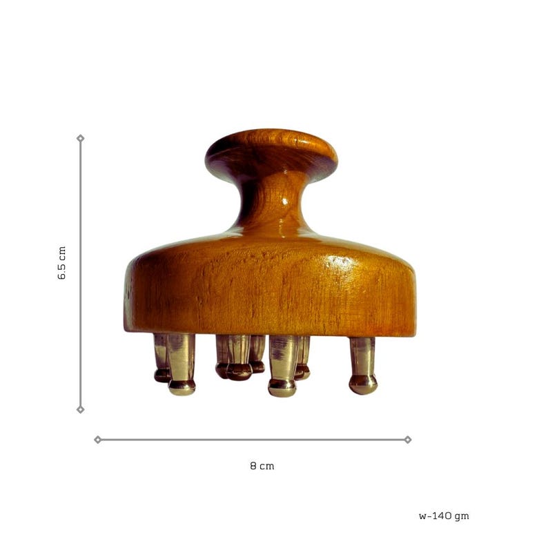 May include: A wooden head massager with a rounded handle and a flat base featuring several metal prongs. The massager is 6.5 cm tall and 8 cm wide. The weight is 140 grams.