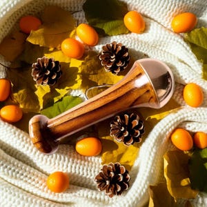 May include: A set of three ceramic mugs with a speckled, cream-colored glaze. Each mug features a different hand-painted floral design in shades of blue, green, and yellow. The mugs have a simple, rounded shape and a comfortable handle.