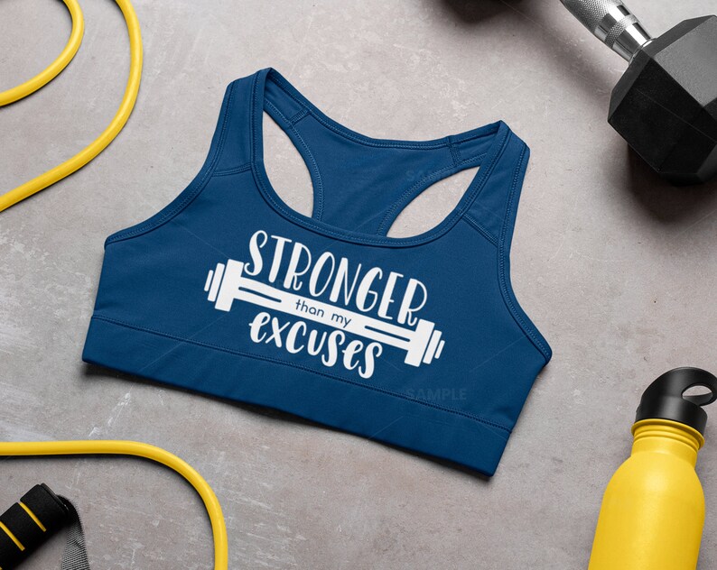 K&ouml;nnte beinhalten: Ein marineblauer Sport-BH mit dem Text "Stronger than my excuses" und einer wei&szlig;en Hantelgrafik.