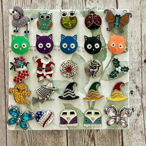 May include: A collection of 20 colorful enamel pins featuring various designs, including animals, holiday themes, and whimsical characters. The pins are displayed on a white background.