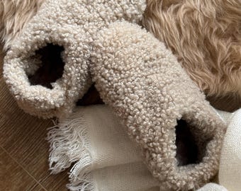 Peut inclure: Une paire de pantoufles beige moelleuses avec une texture douce et duveteuse. Les pantoufles sont faites d'un matériau épais et chaud et ont une coupe confortable.