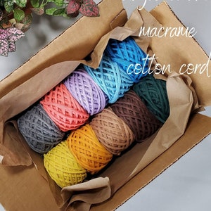 May include: A box filled with eight different colors of single strand macrame cotton cord. The colors are blue, purple, orange, gray, yellow, brown, green, and dark brown.
