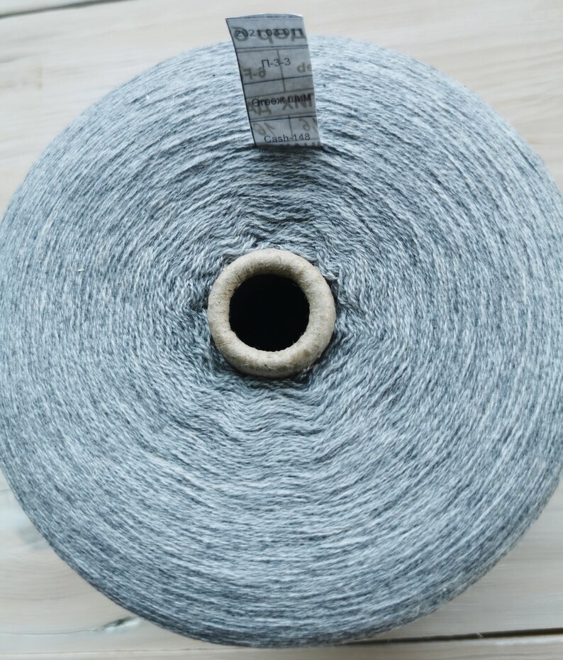 May include: A skein of grey yarn with a white label that reads "Cash 148" and "Г-33".