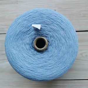 May include: A large spool of light blue yarn.