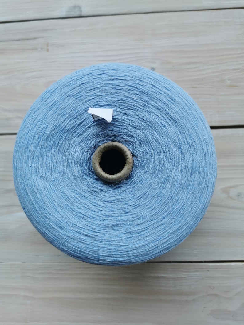 May include: A large spool of light blue yarn.