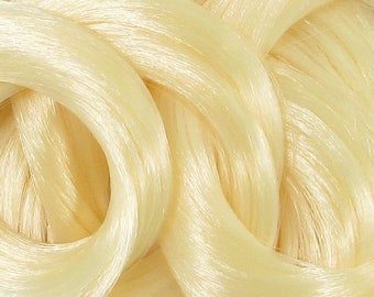 May include: A close-up of a bundle of light blonde hair extensions. The hair is soft and silky, with a slight sheen.
