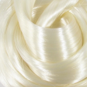 May include: A close-up of a bundle of white, silky yarn. The yarn is soft and smooth, with a subtle sheen.