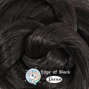 May include: Close-up of black hair extensions, tightly woven together. The image features the text "Edge of Black" and the brand name "Saran" with a unicorn logo.