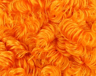 May include: A close-up of a pile of orange curly noodles. The noodles are arranged in a random pattern and are all the same size and shape.