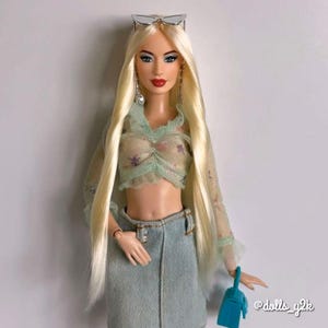 A pale blonde nylon doll hair for rerooting dolls, monster high reroots, standard 11.5 inch fashion dolls, custom rehairing and restoring all doll and toy types. Example Barbie reroot shown.  Doll rehair not included.