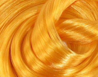 May include: Close-up of a bright yellow, shiny, and silky yarn. The yarn is twisted and looped, creating a swirling pattern.