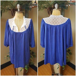 May include: A blue and white polka dot top with a white lace collar. The top has a gathered neckline and three-quarter sleeves.