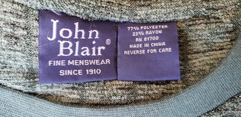 May include: A blue label with white text that reads "John Blair Fine Menswear Since 1910". A second blue label with white text reads "77% Polyester 23% Rayon RN 81700 Made in China Reverse for Care".
