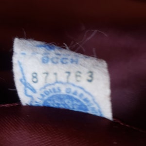 Puede incluir: Una etiqueta blanca con texto azul y un sello azul. La etiqueta tiene el texto "871763" y un sello azul con el texto "Louis Gallice Paris".