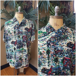May include: A white short-sleeved button-down shirt with a colorful print of palm trees and vintage cars. The shirt has a blue, green, red, and black color scheme.
