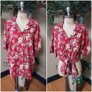 May include: A red short-sleeved button-up shirt with a floral and tropical print. The shirt has a relaxed fit and is tied at the waist.