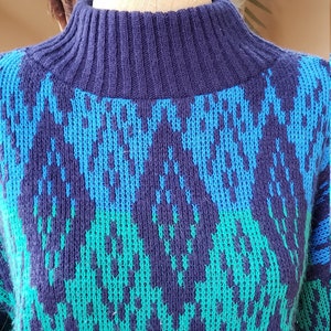 May include: A blue, green, and black patterned sweater with a high neck.