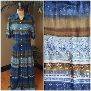 May include: A long, blue and brown striped dress with a button-up front and short sleeves. The dress has a paisley pattern and is made of a soft, flowing fabric.