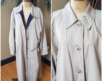 May include: A beige trench coat with a button closure and a black lining. The coat has a collar and long sleeves.