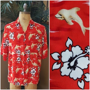 May include: Red short-sleeved button-up shirt with a tropical print featuring white hibiscus flowers and beige dolphins.