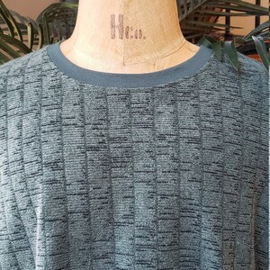 May include: A dark green, textured, long-sleeved shirt with a ribbed pattern.