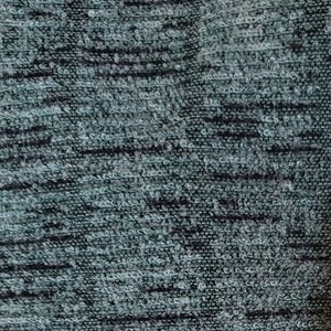 May include: Close-up of a dark gray textured fabric with a subtle pattern. The fabric has a soft, fuzzy feel.