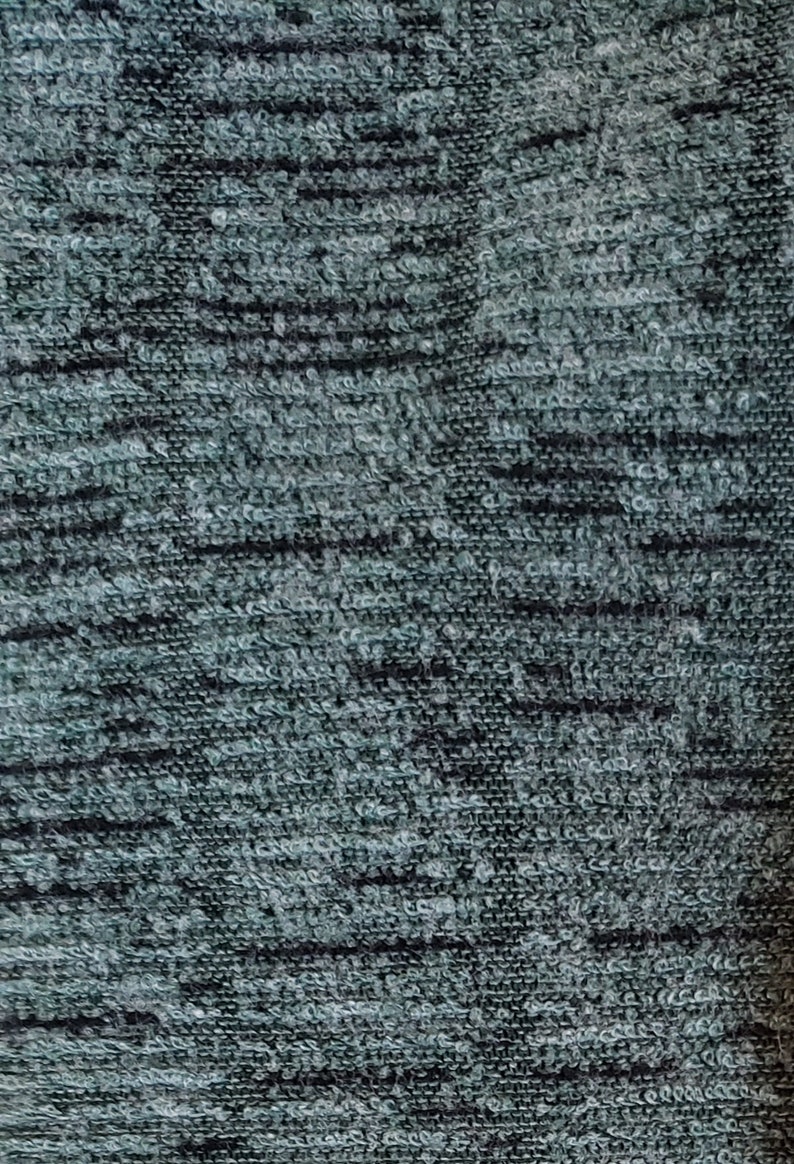 May include: Close-up of a dark gray textured fabric with a subtle pattern. The fabric has a soft, fuzzy feel.
