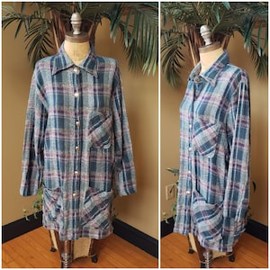 May include: A long-sleeved plaid shirt with a button-up front and two large pockets. The shirt is made of a soft, fuzzy fabric and is a mix of blue, purple, and gray.