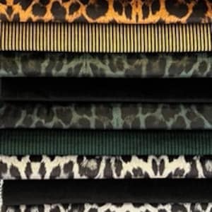 May include: A stack of fabric swatches with various animal print patterns, including leopard, zebra, and cheetah. The swatches are arranged in a vertical stack, with the top swatch being a leopard print and the bottom swatch being a blue and white striped pattern.