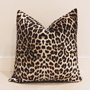 May include: A brown and black leopard print throw pillow with a soft, plush texture.