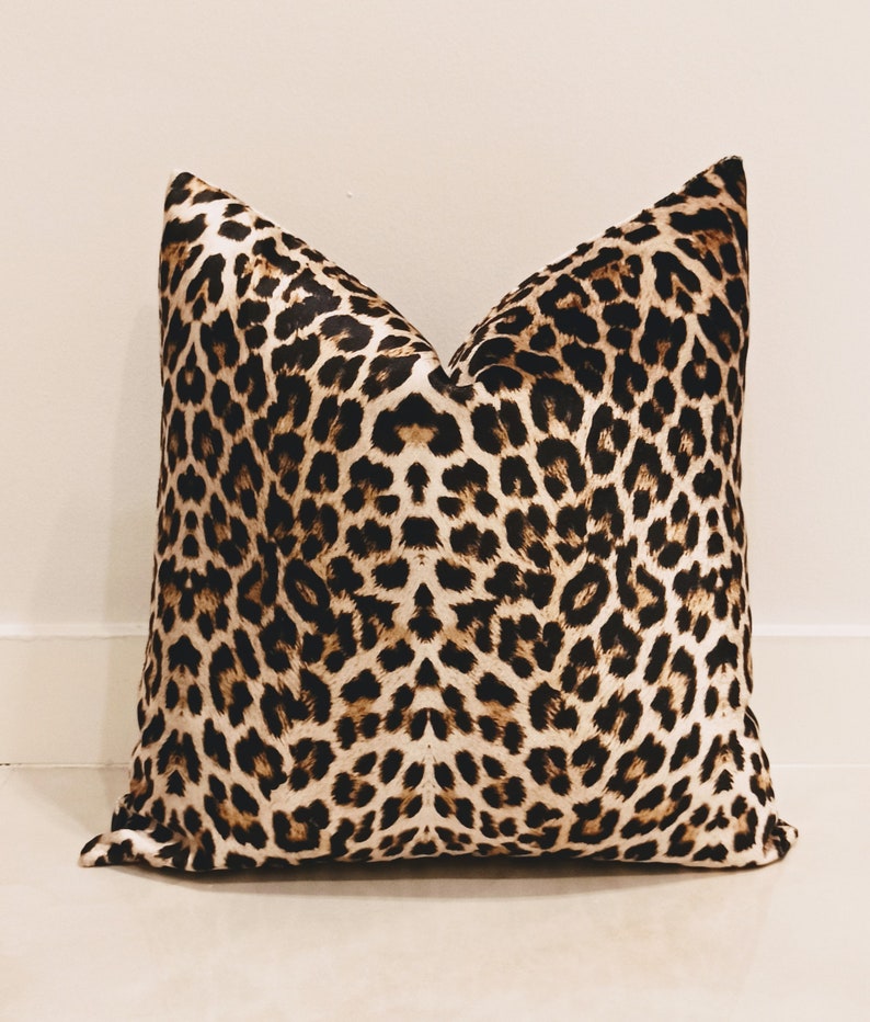 May include: A brown and black leopard print throw pillow with a soft, plush texture.