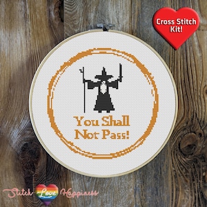 May include: Cross stitch pattern featuring a wizard with a staff and the text "You Shall Not Pass!" in a circle. The pattern is on white Aida cloth and is ready to be stitched.