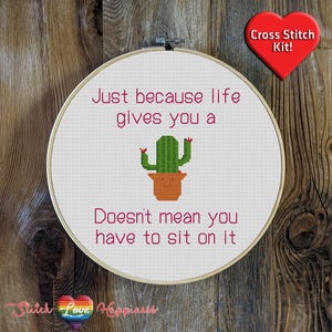 Puede incluir: Patrón de punto de cruz con un cactus en una maceta con el texto "Just because life gives you a doesn't mean you have to sit on it".