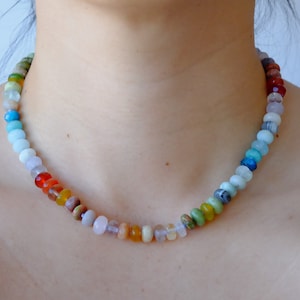17 inches gemstone candy necklace strung on lilac silk. Agate, amazonite, apatite, citrine, fluorite, jade, jasper, labradorite, onyx, unakite, and quartz are used. There is a knot between each stone and finished with a 14k gold filled bold clasp