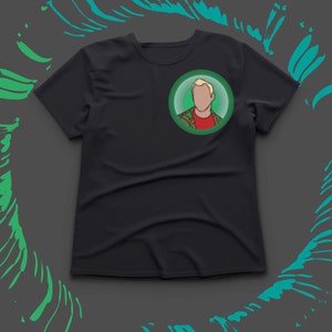 May include: Black t-shirt with a circular graphic of a person with blonde hair, a red shirt, and a green jacket. The graphic is set against a green background. The shirt is on a grey background with green brushstroke accents.