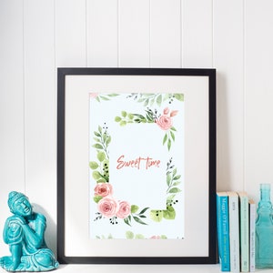 May include: A framed print with a watercolor floral border and the text "Sweet Time" in the center. The flowers are pink and green and the background is light blue.