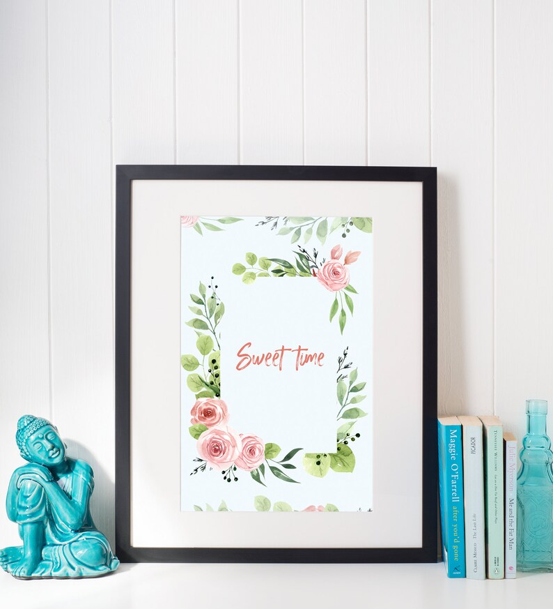 May include: A framed print with a watercolor floral border and the text "Sweet Time" in the center. The flowers are pink and green and the background is light blue.