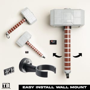 May include: A gray and brown Lego hammer with a wall mount. The hammer has a gray head and a brown handle with white stripes. The wall mount is black and has a curved design. The text "EASY INSTALL WALL MOUNT" is at the bottom.