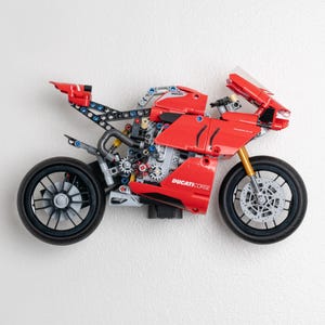 May include: A red and black Ducati Corse Lego motorcycle model with a detailed engine and wheels.