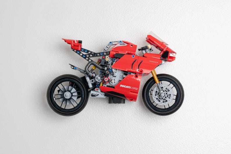 May include: A red and black Ducati Corse Lego motorcycle model with a detailed engine and wheels.