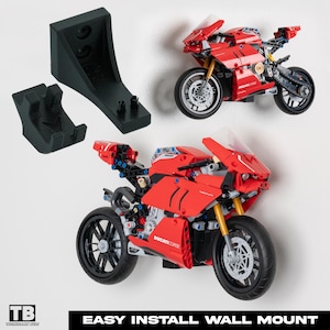 May include: A red and black Lego Ducati Corse motorcycle model with a wall mount. The wall mount is black and has two prongs for easy installation.