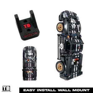 May include: Black Lego race car model with white stripes and gold wheels, displayed in multiple angles. A black wall mount with red text is also shown. The text "EASY INSTALL WALL MOUNT" is at the bottom.