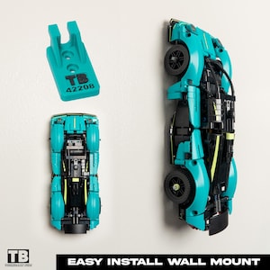 May include: A teal and black model car made of interlocking blocks, mounted on a white wall. A teal mounting bracket with the text "TB 42208" is also shown. The words "EASY INSTALL WALL MOUNT" are at the bottom.