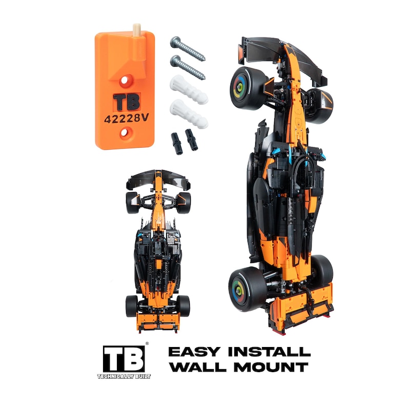 May include: An orange plastic wall mount bracket labeled TB 42228V, two metal screws, two white plastic wall anchors, and two small black connectors. Two black and orange model race cars are shown, one vertical and one horizontal, for display.